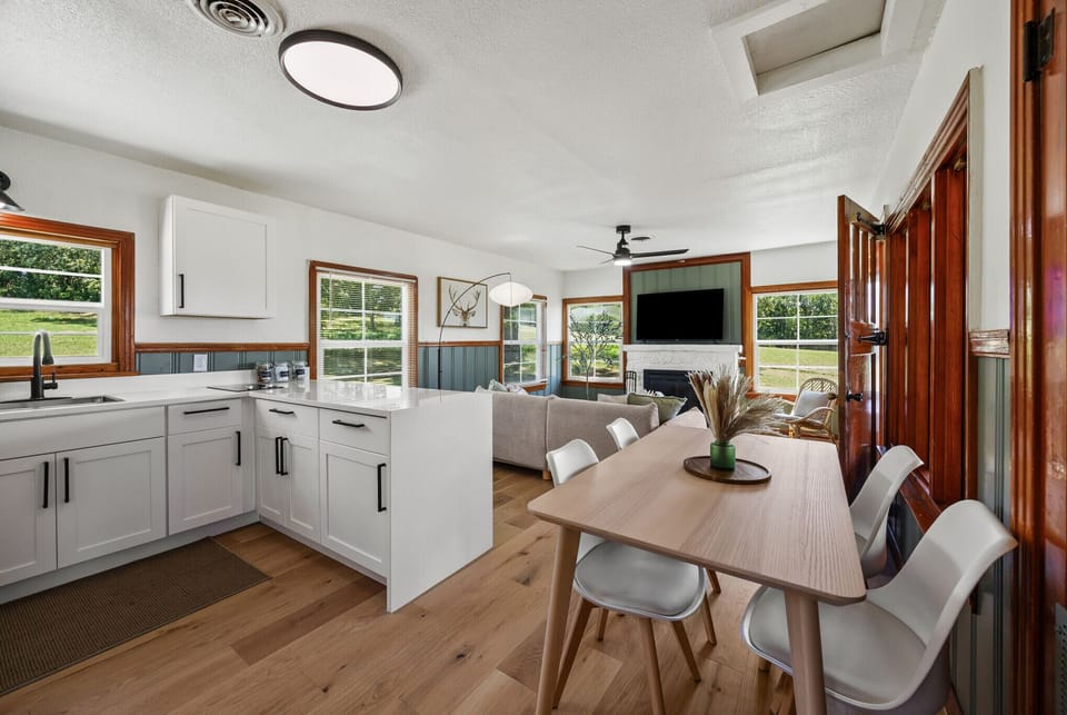 Bright modern kitchen and living space with wood accents and large windows.