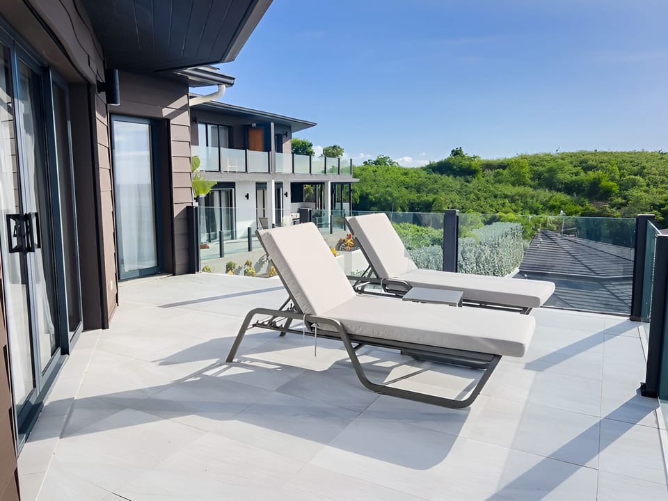 Soak up the sun on spacious loungers overlooking lush hills.