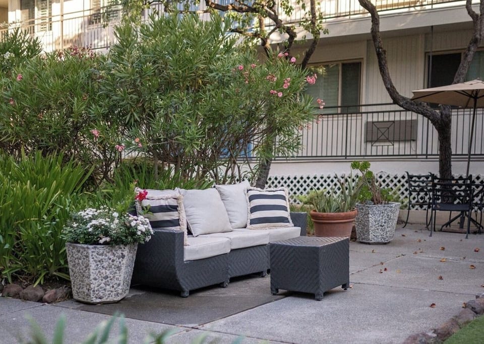 Lounge among blooming planters in a peaceful, private courtyard.