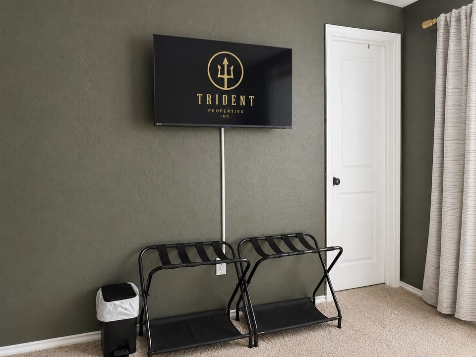 Wall-mounted TV and dual luggage racks for a convenient guest stay