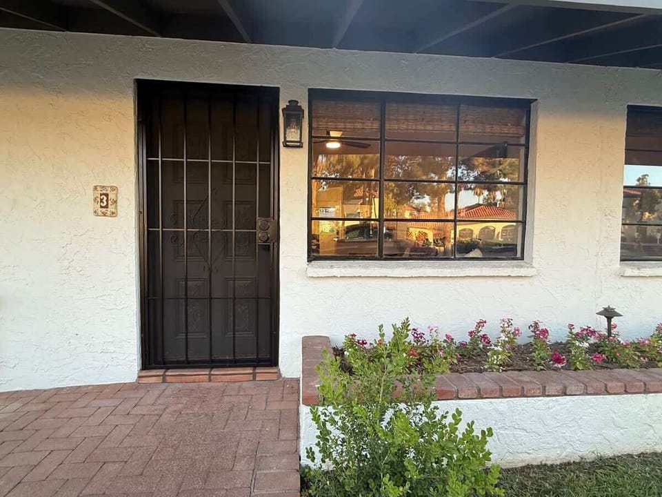 Charming private entrance with a decorative security door and colorful flower boxes.