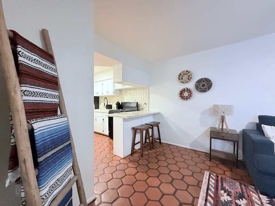 Warm Saltillo tile and a rustic breakfast bar with handcrafted stools create a cozy, Southwestern-inspired spot to sip coffee or share a casual meal.