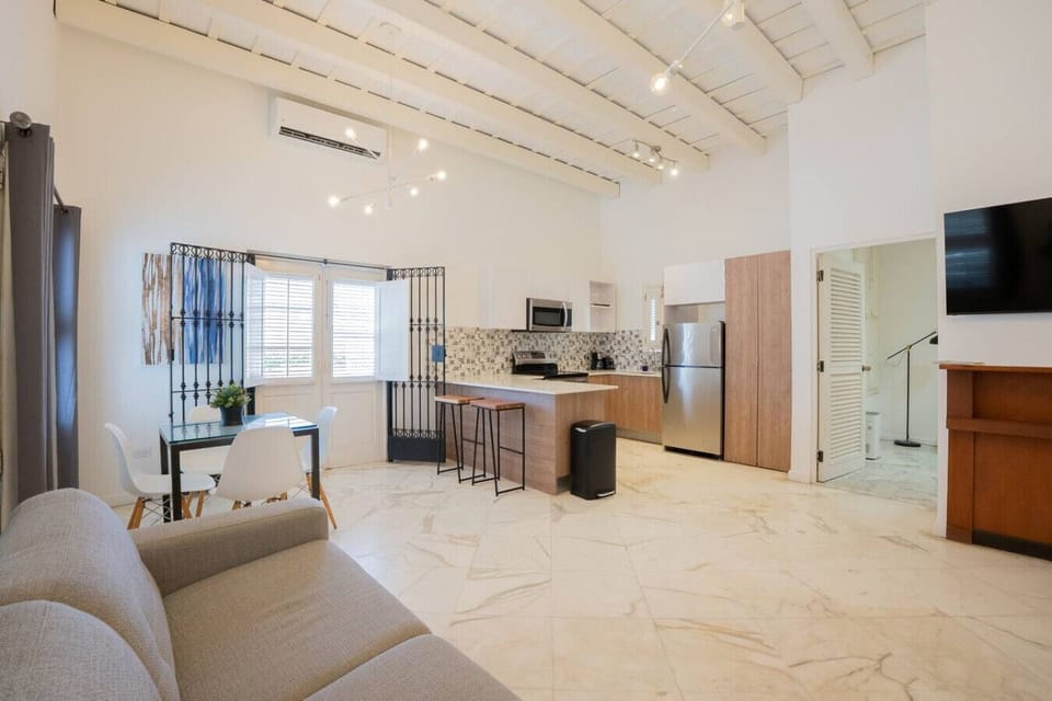 Airy open layout with kitchen, dining, and lounge under beamed ceilings.