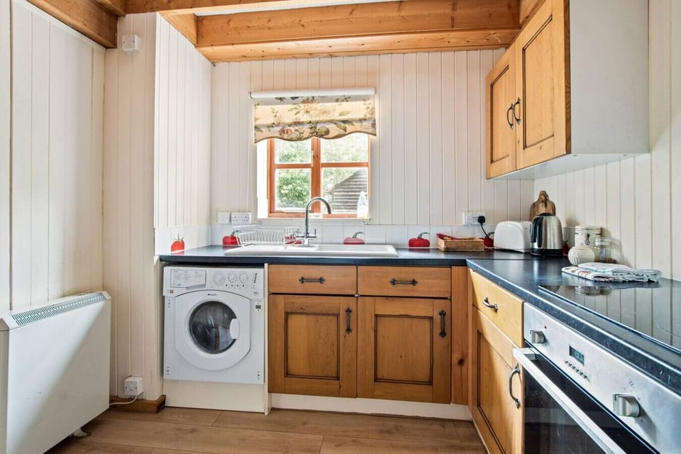 Kitchen sink with garden outlook and wooden cabinetry