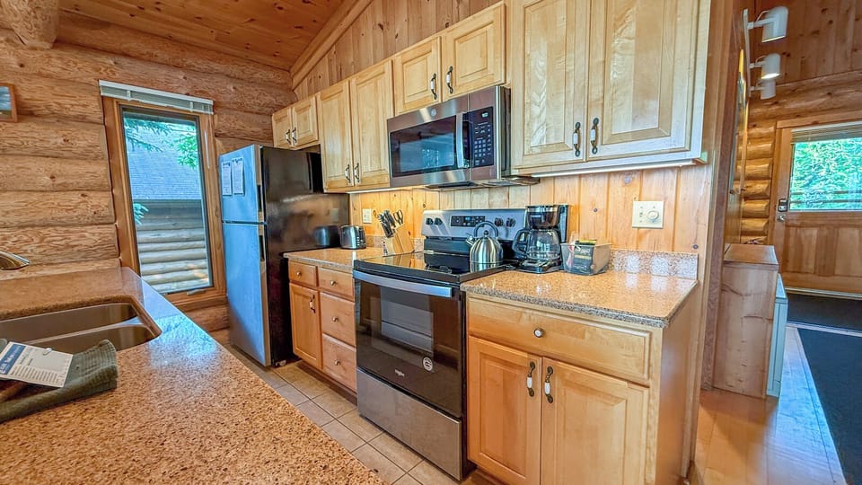 Step into your cozy cabin kitchen, where warm wood surrounds you and modern appliances make cooking a breeze. Gleaming counters and everything you need await your mountain meal prep.