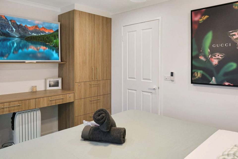Bedroom with TV, built-in storage, and workspace area.