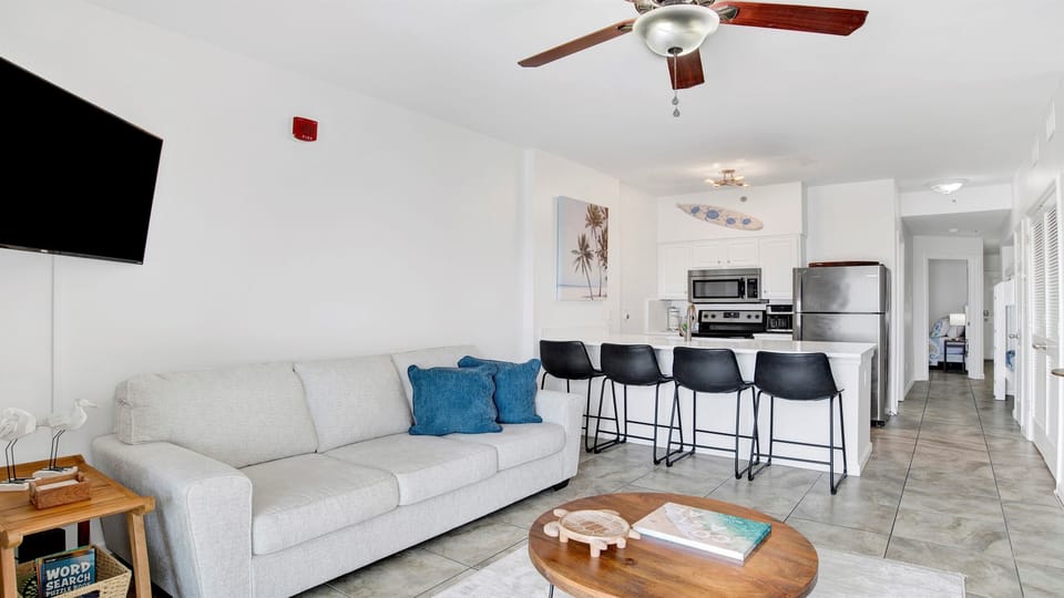 Living room with sleeper sofa, a 2nd sofa, smart TV, ceiling fan and balcony access