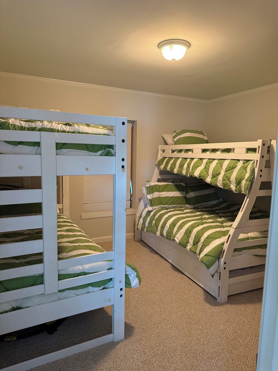 Kids' room with two bunk beds and a trundle bed.