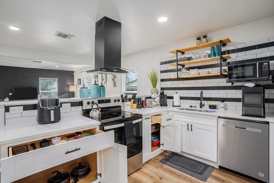Fully equipped kitchen with air fryer, blender, cookware, and more.