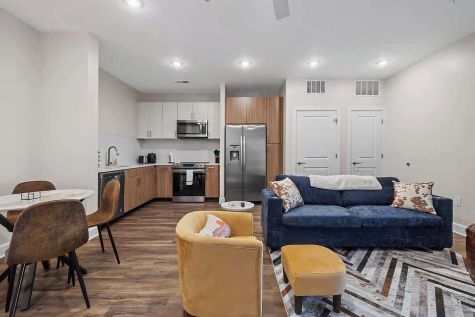 - Bright open living area with modern decor ideal for comfortable stays  
- Cozy seating and stylish accents creating a warm inviting space  
- Kitchen nearby adds convenience for guests and extended visits  