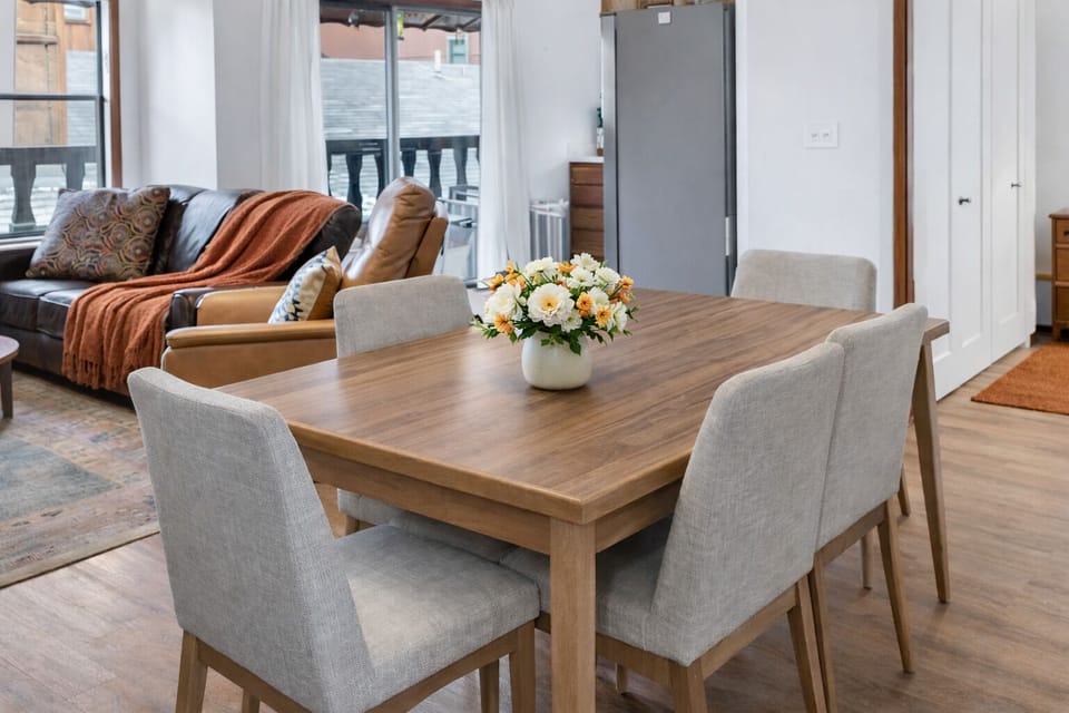 Cozy dining nook for six with entry hooks and modern wood finishes