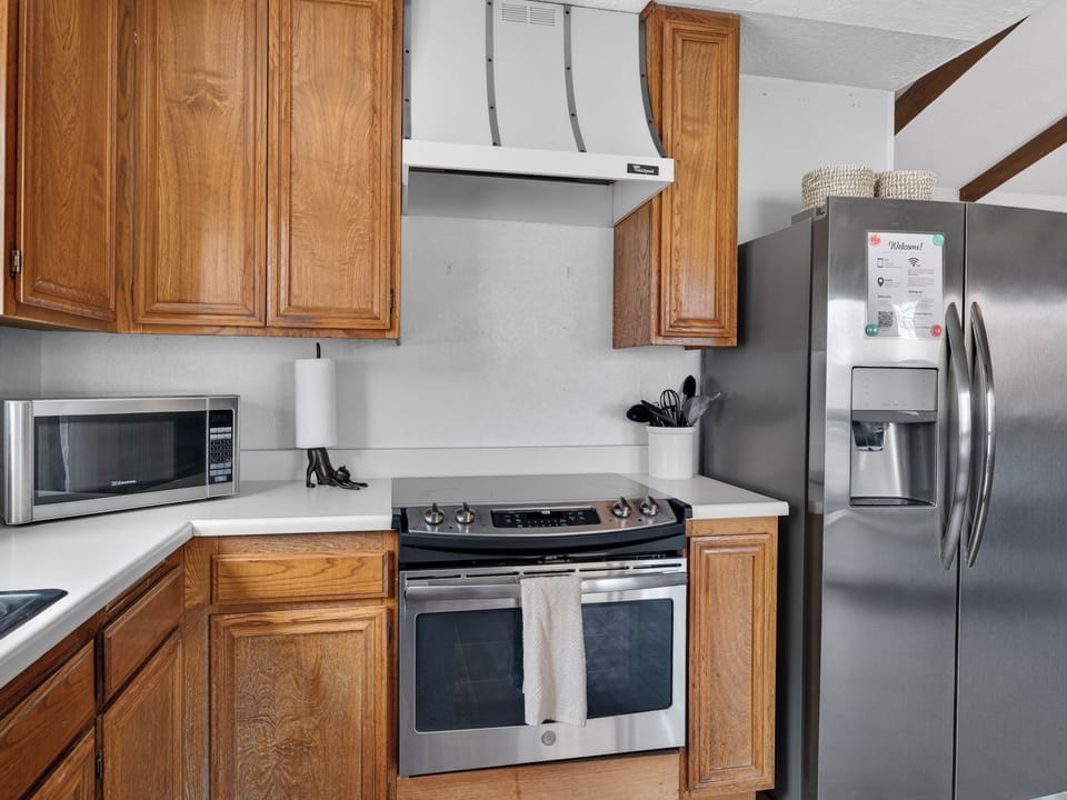 Bright kitchen with stainless appliances, smooth-top range, and ice fridge