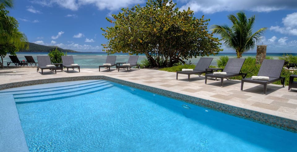 Unwind poolside as turquoise waves shimmer just beyond.