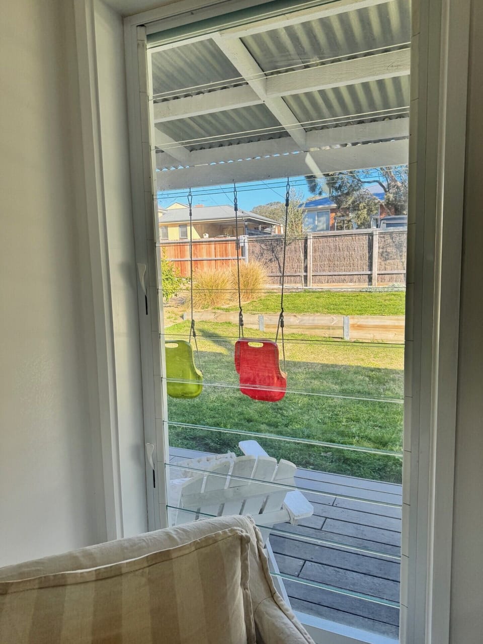 Indoor view out to the swings and spacious front yard for play.