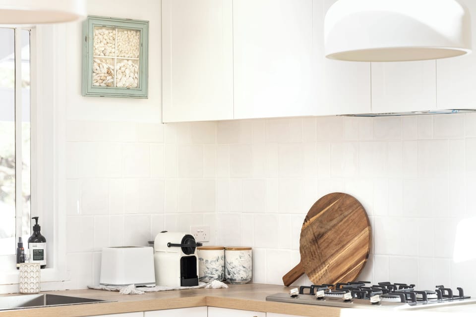 Well-equipped kitchen with oven, cooktop, microwave, and coffee machine.