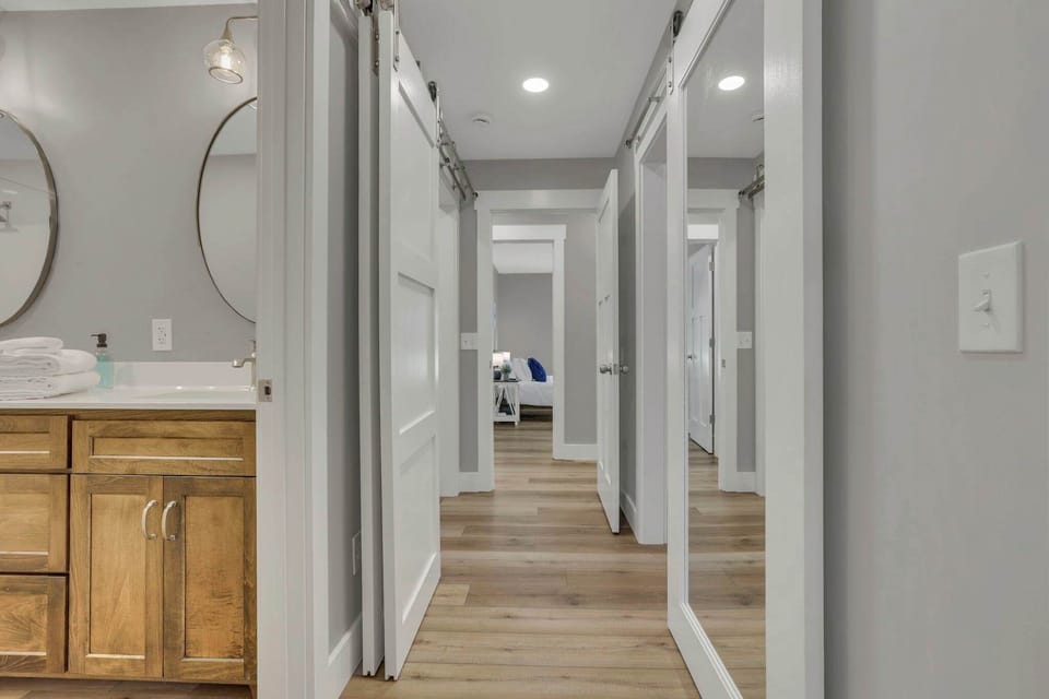 Hallway leading to one of the master suites, featuring gorgeous barn doors that conceal the laundry room and a spacious walk-in closet.