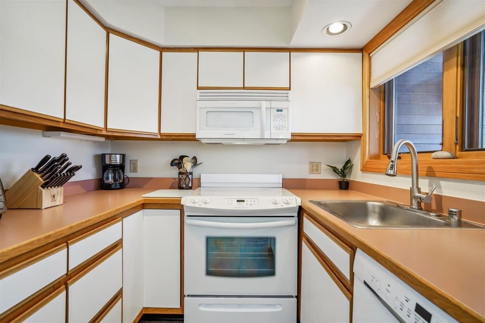 Bright cabinetry and functional workspace create a comfortable setup for cooking and gathering.