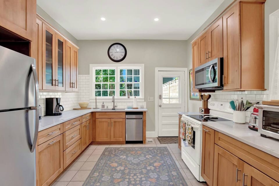 Fully equipped kitchen featuring a refrigerator, dishwasher, glass-top 4-burner stove with oven, microwave, toaster oven, blender, and drip coffee makers. The kitchen is fully stocked with everything you need to cook and enjoy meals during your stay.