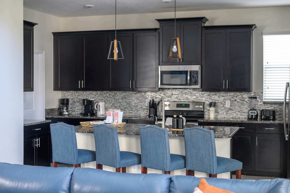 Spacious kitchen with granite counter tops, stainless appliances and fully stocked with all cooking and dining necessities. Open floor plan connects to the living and dining rooms. 