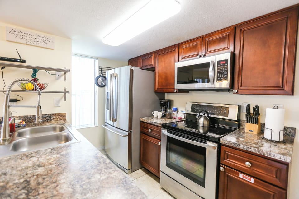 FULLY EQUIPPED KITCHEN – Includes stove, oven, microwave, dishwasher, refrigerator, coffee maker, and hot water kettle