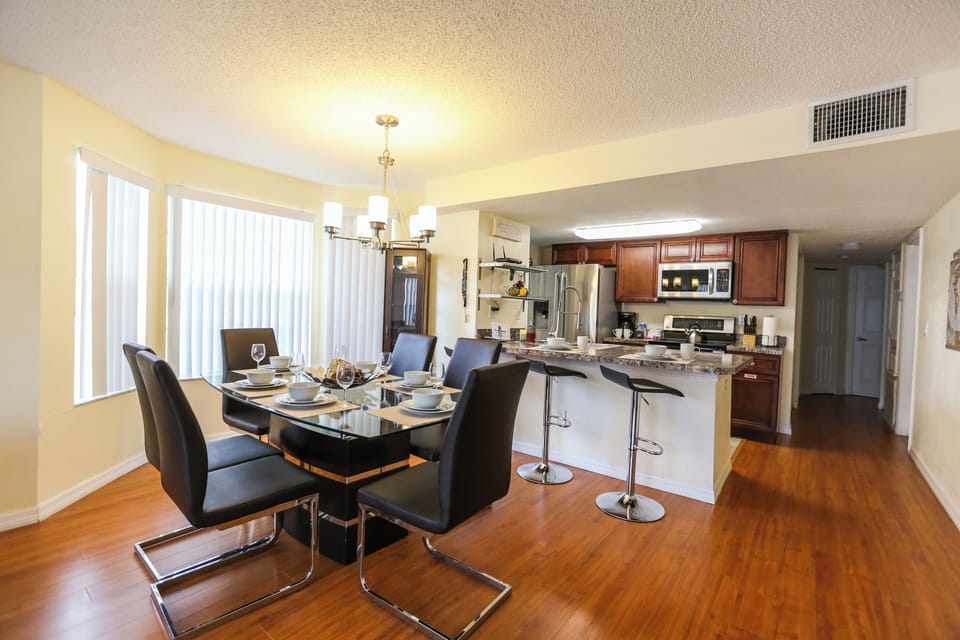 The welcoming dining space is filled with abundant natural light, thanks to large windows that brighten the room and create a warm, inviting atmosphere—perfect for enjoying meals with family and friends.