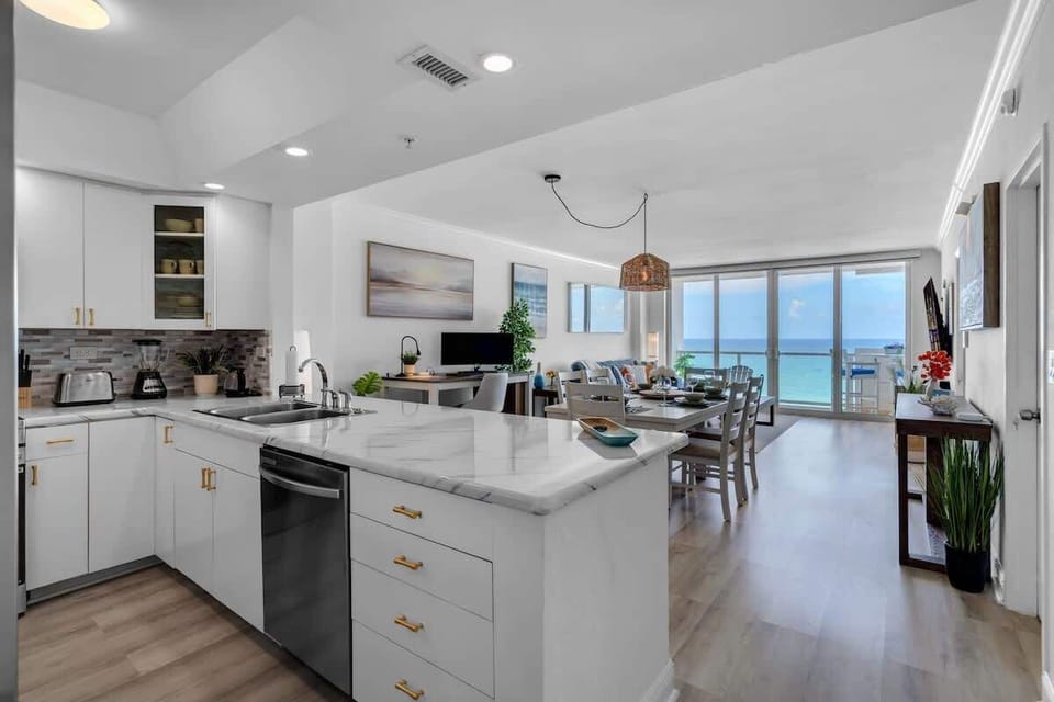 Cook with a view 🍳🌊 This coastal kitchen features marble counters, oceanfront dining, and beachy vibes.