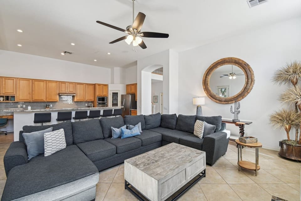 Relax in the spacious open-plan living room with a cozy sectional, stylish decor, and a fully equipped kitchen just steps away. Perfect for lounging or gathering with friends and family.
