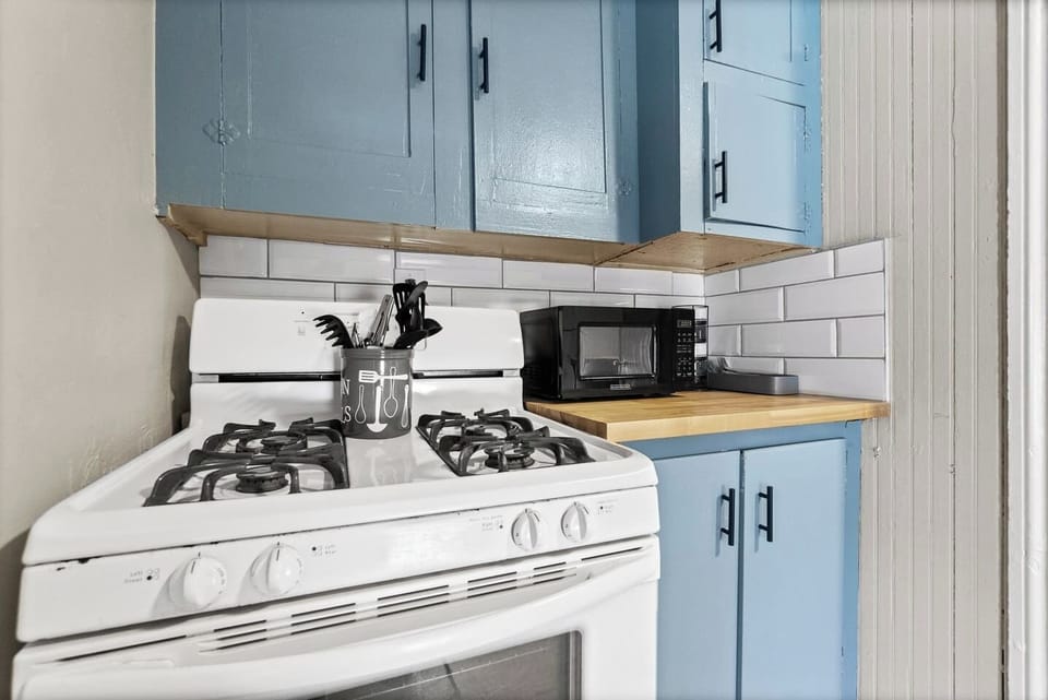 Gas range and microwave ready for home-cooked meals.