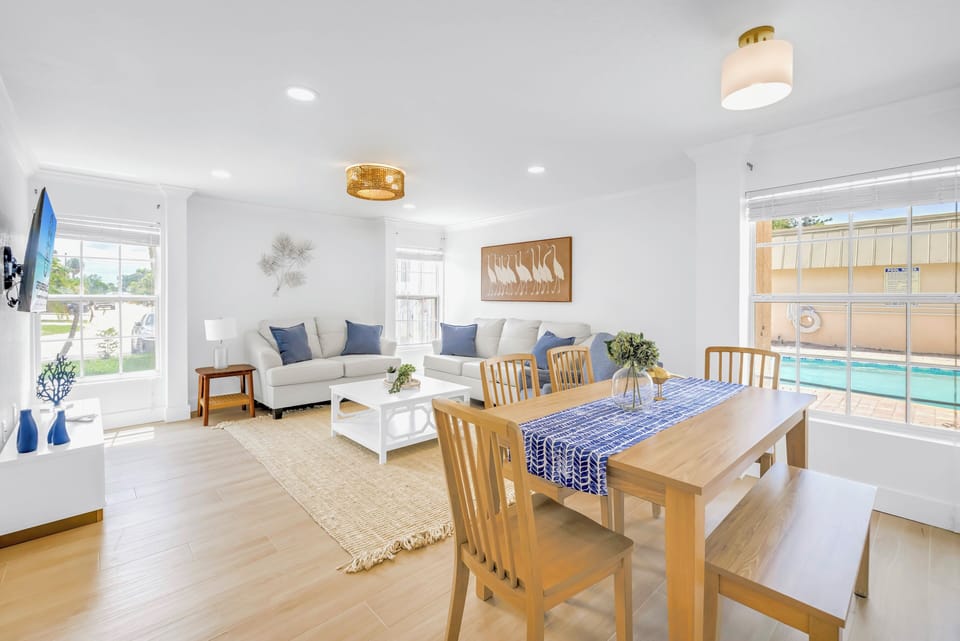 Dining area just outside kitchen leading to living area with pool view.