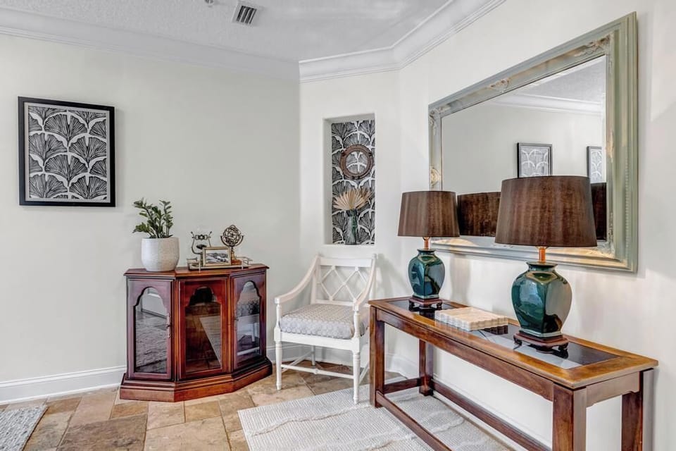 - Warm and welcoming corner with wood console, twin lamps, and large mirror
- Decorative cabinet and potted plant add texture and cozy visual appeal
- Neutral walls and natural flooring enhance the peaceful ambiance