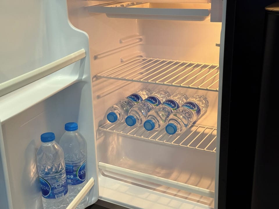 You chill bottled water for yourself and guests in your organized fridge.
