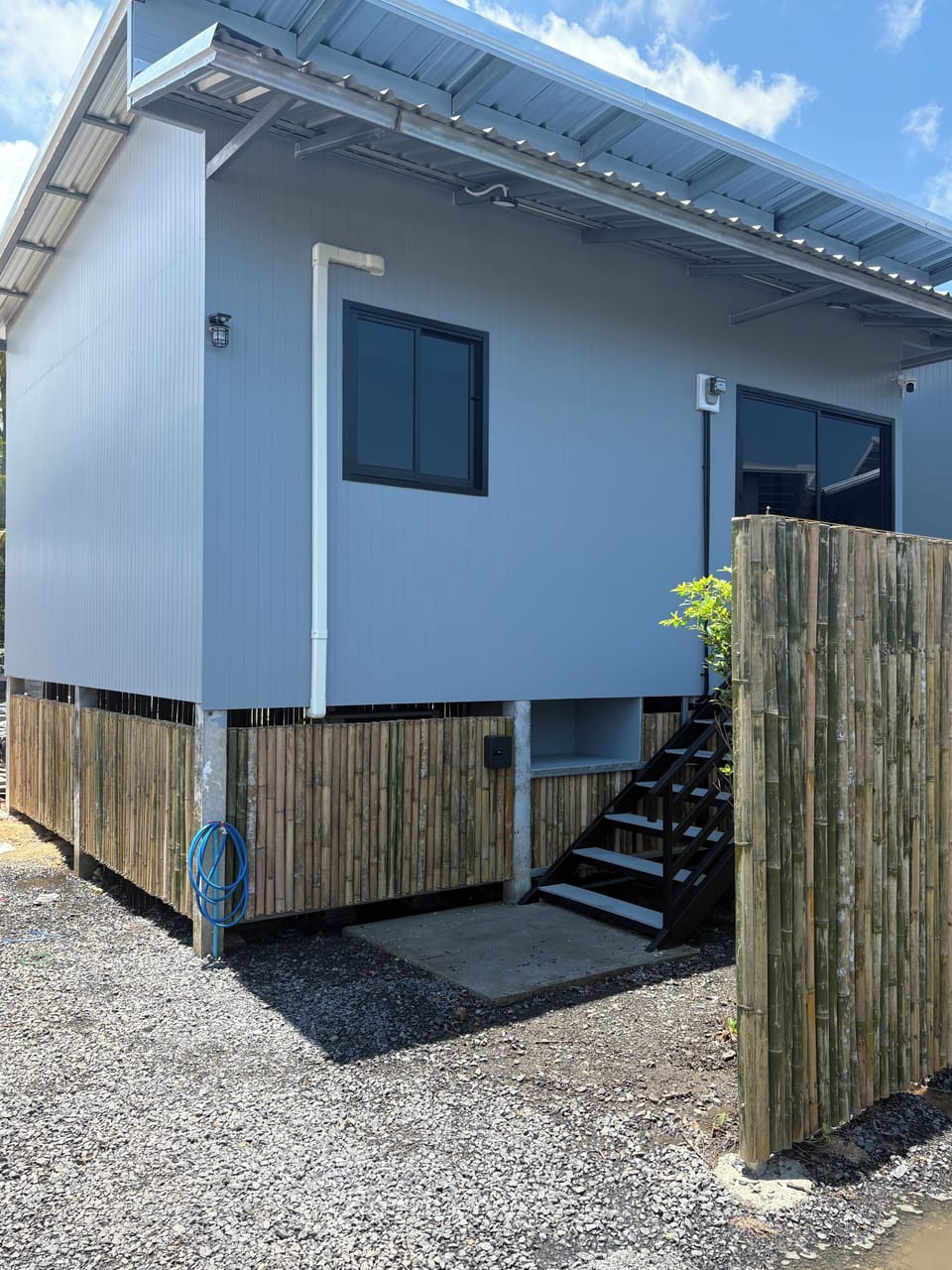 You walk up the stairs to your modern cozy home with bamboo fencing.