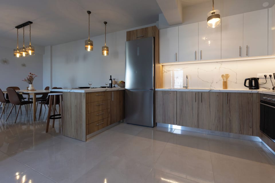 Fully equipped kitchen with counter and four stools.