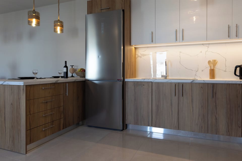 Fully equipped kitchen with counter and four stools.