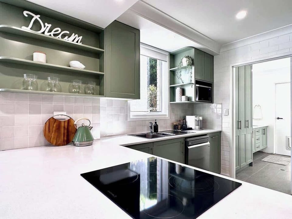 Kitchen flows onto laundry/bathroom with washer and dryer