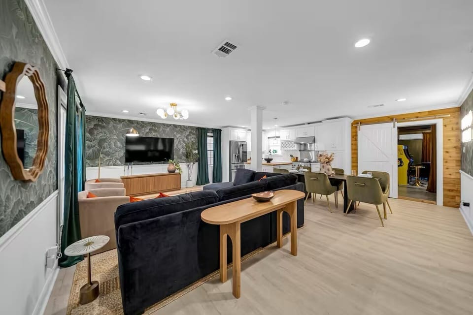 Open-plan living with bold decor, large TV, and easy kitchen access.