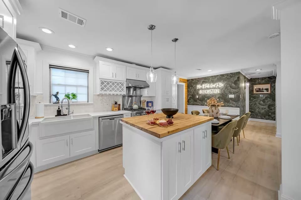 Modern kitchen with island seating, stainless appliances, and open dining.