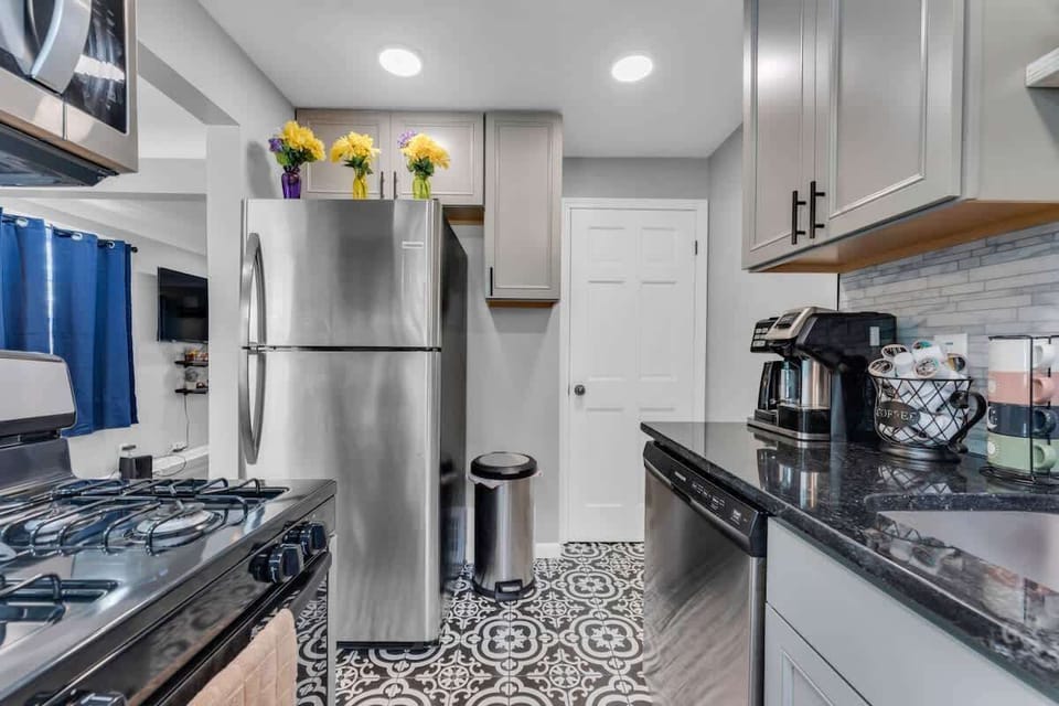 - Kitchen with stainless steel fridge and dishwasher   - Black stone counters and modern tile backsplash   - Fully stocked with coffee maker and cooking tools  