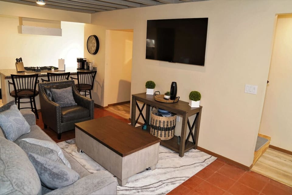 Living Room - Seating Area Leads into Kitchen, TV, Island with Seating, and Stairs