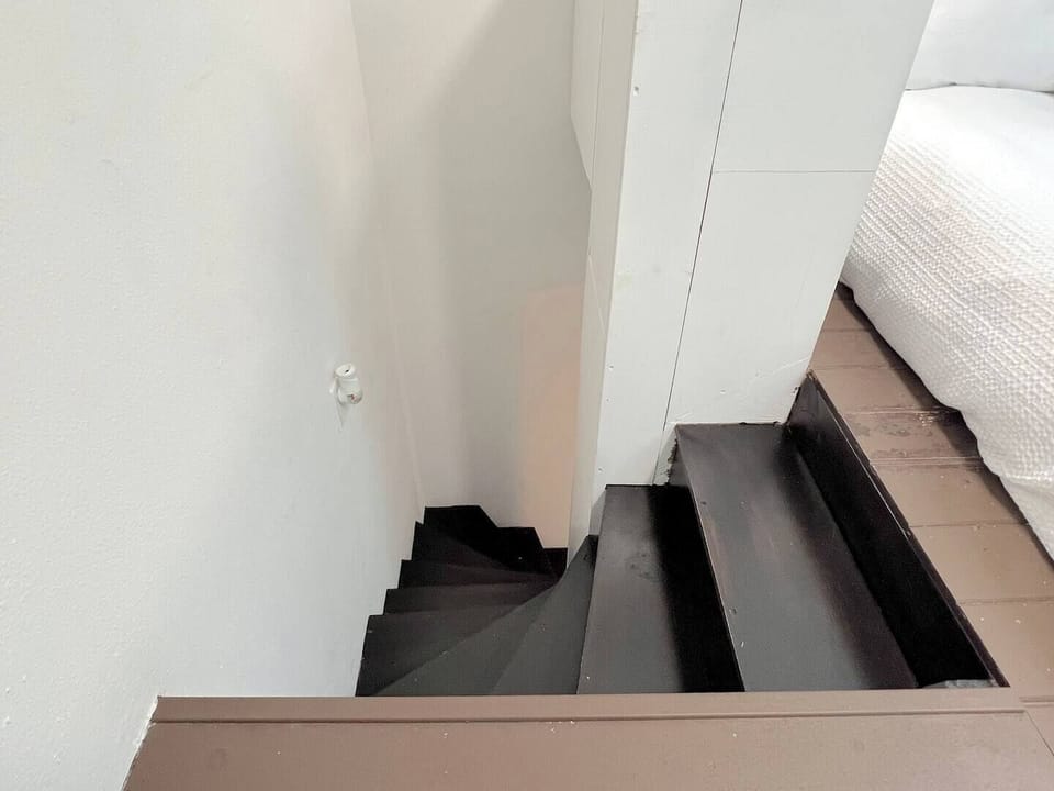 A cozy spiral staircase leads up to the bedroom area - please note that the steps are compact and curved, so we recommend using caution when going up or down.