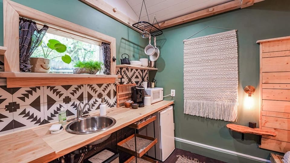Whip up simple meals or morning coffee in this thoughtfully designed kitchenette, featuring open shelving, unique tile accents, and a warm, earthy vibe that makes you feel right at home.