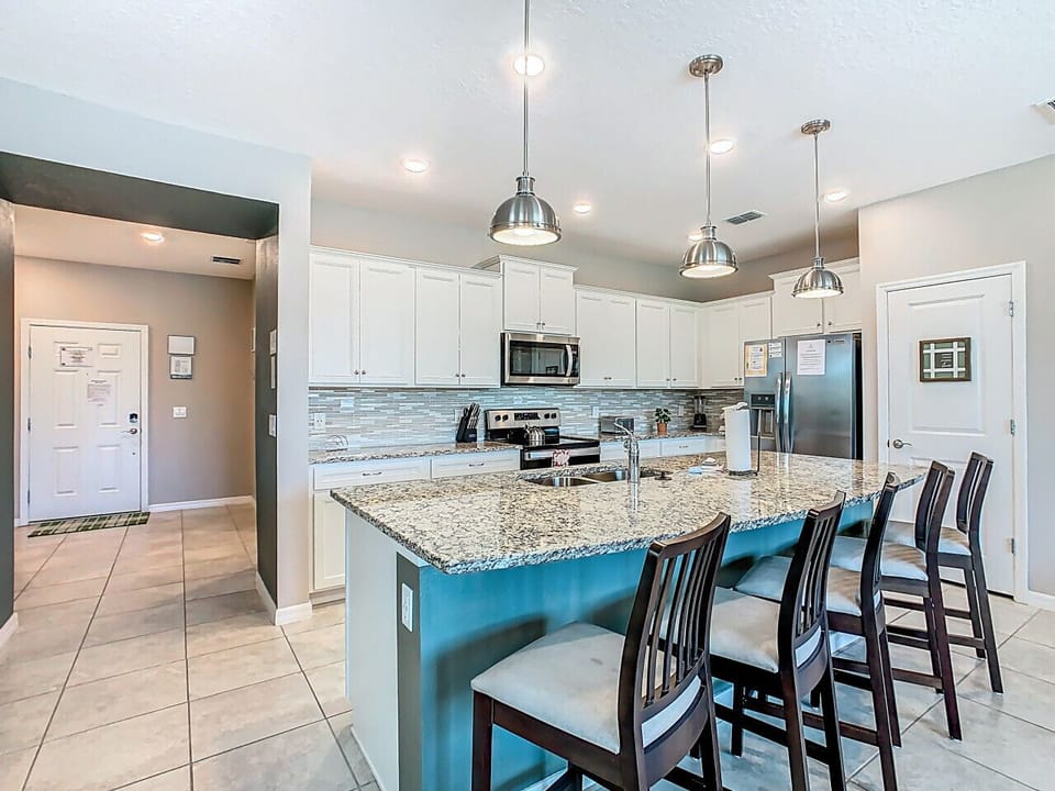 Contemporary kitchen with granite counters and bar stools.