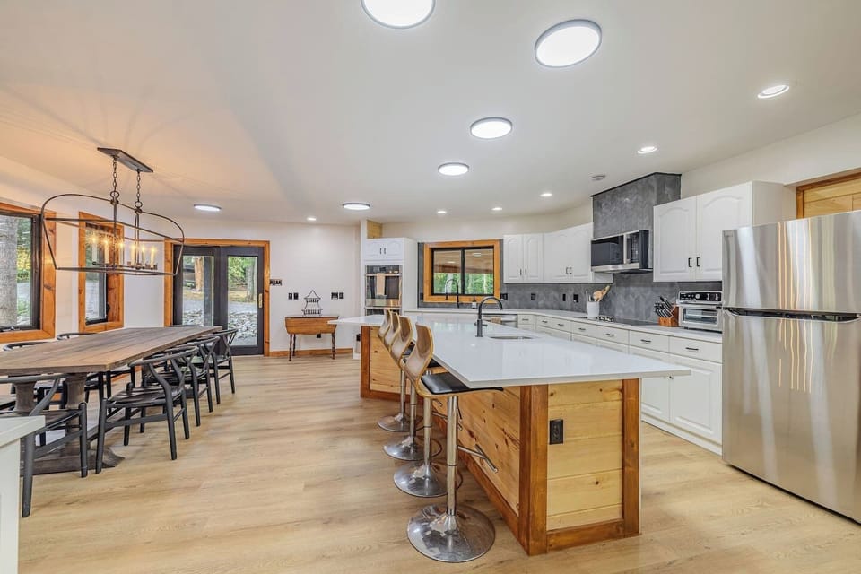 A fully appointed chef’s kitchen showcases full-size stainless steel appliances, a Keurig/drip coffee duo, air fryer, slow cooker, and all the thoughtfully curated serving pieces needed to create memorable family meals.