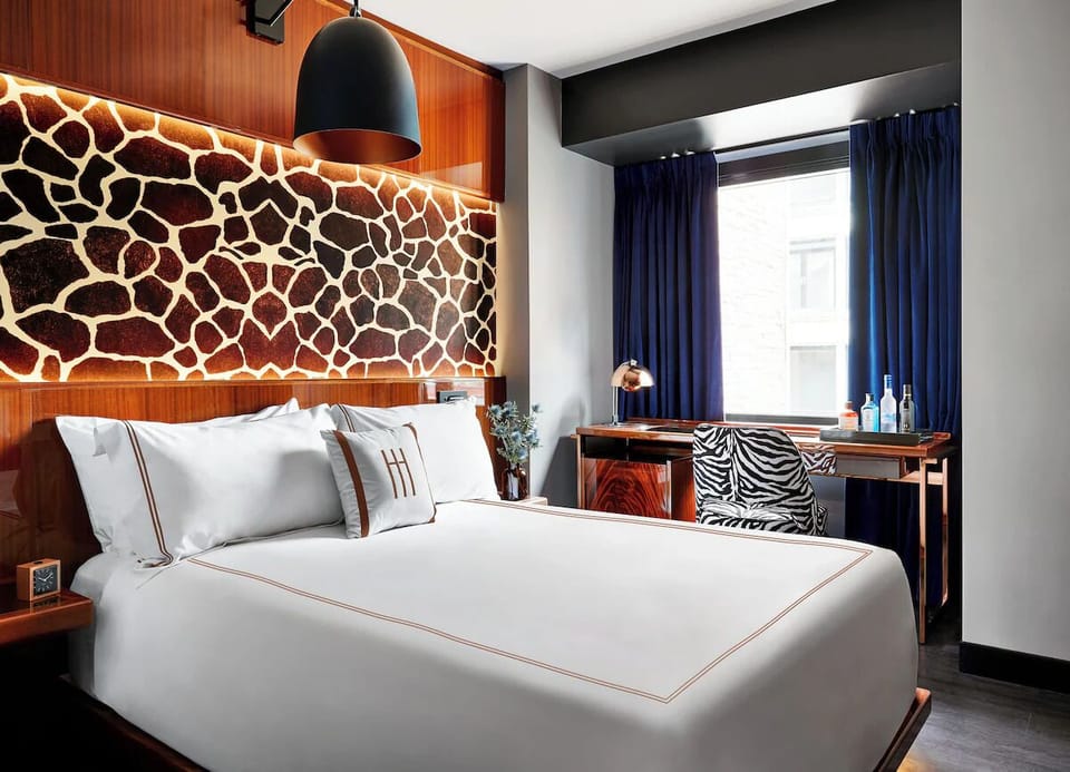 Unwind in crisp linens beneath bold, artful headboard lighting.