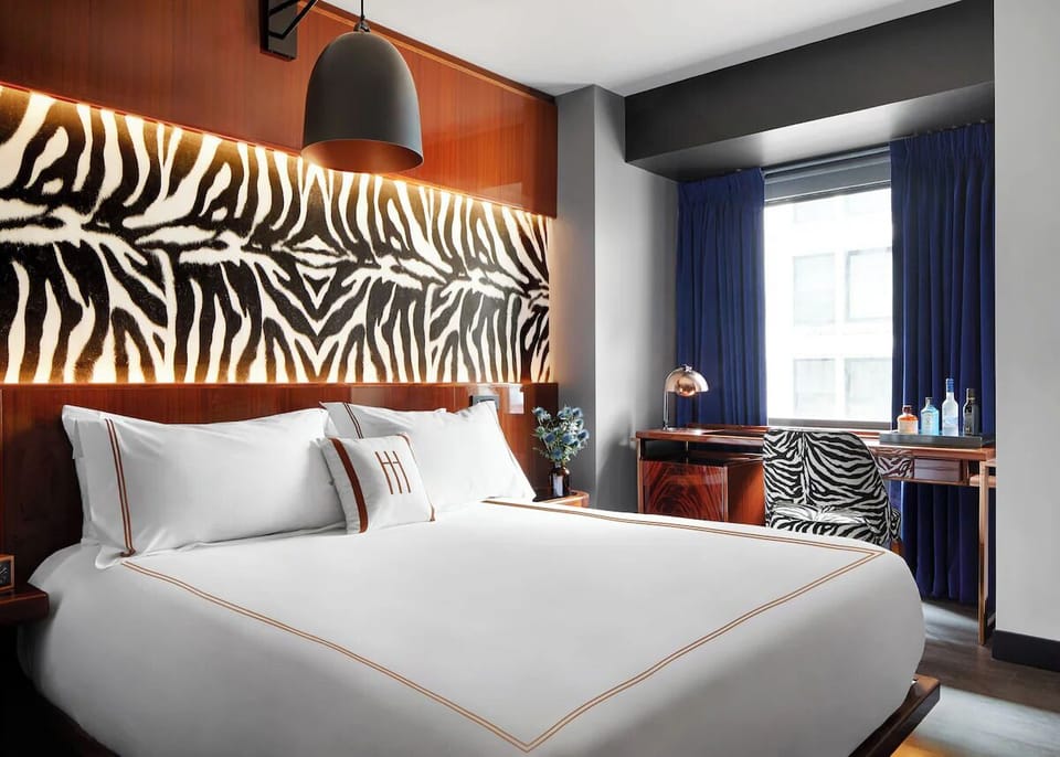 Sink into plush bedding with dramatic headboard and soft lighting.