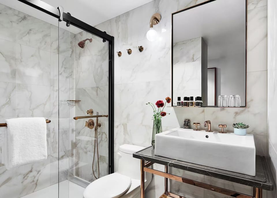 Refresh in a marble-clad shower with chic brass accents