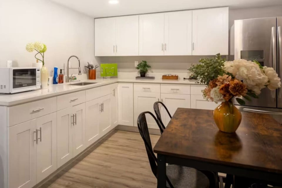Modern kitchen with sleek white cabinetry, stainless steel appliances, and a cozy dining space, perfect for cooking and enjoying meals together 🍴✨