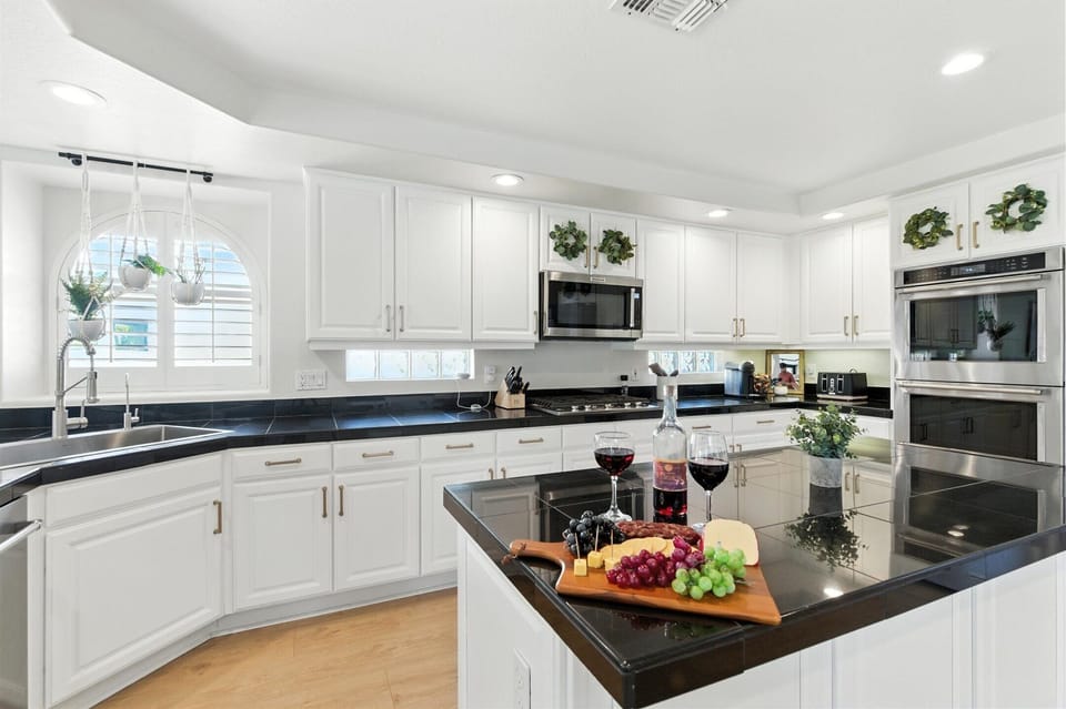 Fully equipped kitchen with stainless steal appliances, kitchen island, and snow cone machine.
