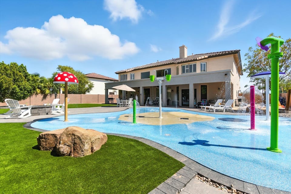 Resort-style backyard with a Splash Pad, sun loungers, outdoor dining area, flattop grill, fire pit with surrounding seating, private patio with outdoor seating, and a basketball hoop.