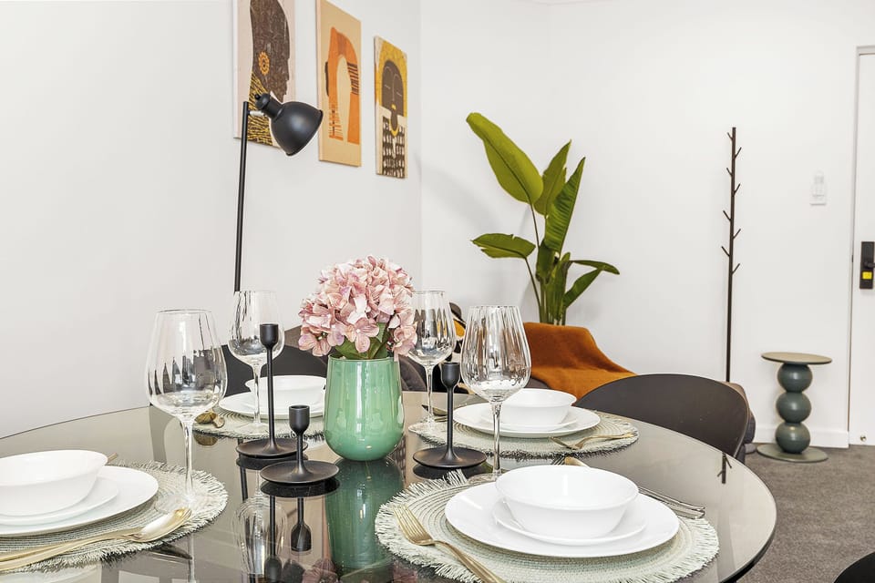 Perfect for making memories, this beautifully set round table comfortably seats four, complete with elegant place settings and a charming centerpiece.